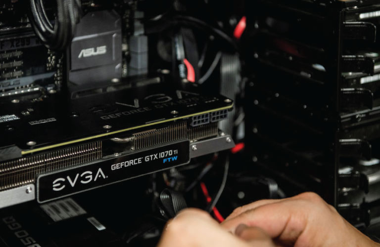 Technician plugins in EVGA GeForce GTX1070Ti video card into ASUS motherboard on PC