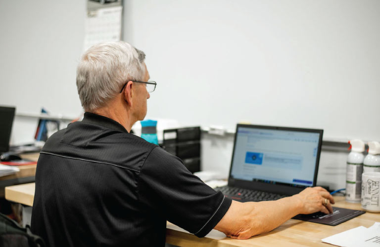 Computer repair technician inspects a laptop at the Hi-Tech service center in Grande Prairie